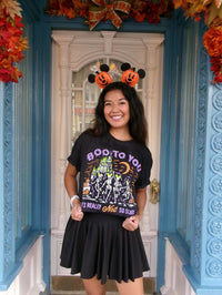 Women wearing a Not So Scary shirt,  a MNSSHP Inspired t-shirt with dancing skeletons and magic castle located in Magic Kingdom located at Disney World and Disneyland. It is part of the Boo To You Parade. 