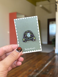 Madame Leota Haunted Mansion inspired enamel pin on Main Street Tourist backing card, held by hand indoors – Disney inspired enamel pin for collectors and trading.